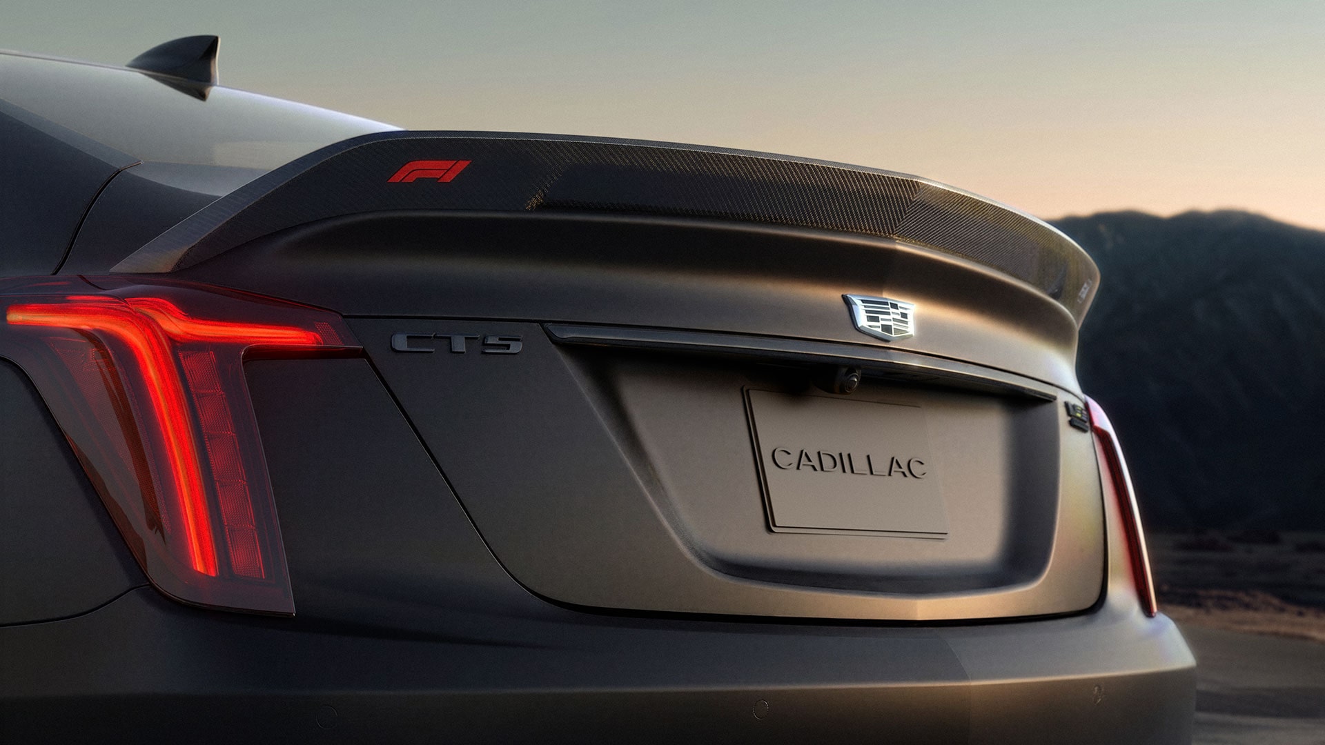 A Blue Cadillac CT5-V Parked on an Open Desert Road With Distant Mountain Peaks Under a Clear Sky.