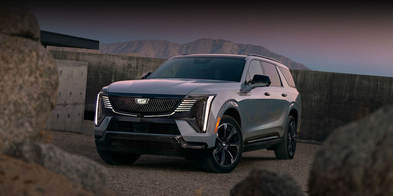 Front Three-Quarter View of the 2026 ESCALADE IQL Parked near a Concrete Wall During Dusk