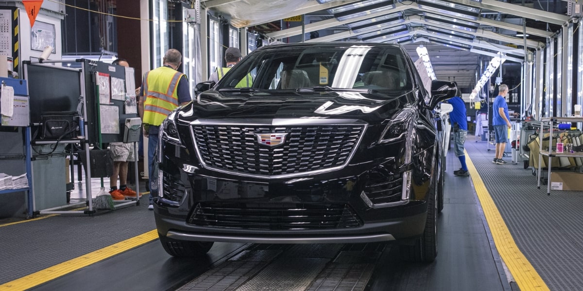 Cadillac XT6 en la línea de ensamble mientras personas trabajan a su alrededor