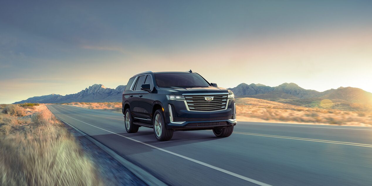 2024 Cadillac Escalade Driving Down the Road with a Beautiful Mountain Backdrop