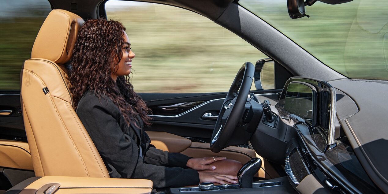 A Woman Using the Super Cruise Hands-Free Driving Feature in her Cadillac Escalade