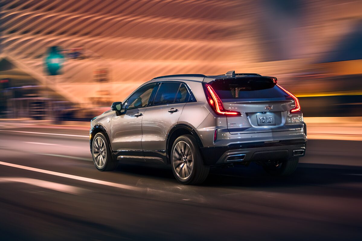 Fashionably Dressed Woman Walking Away From Her Parked 2024 Cadillac XT4 On Parking Structure