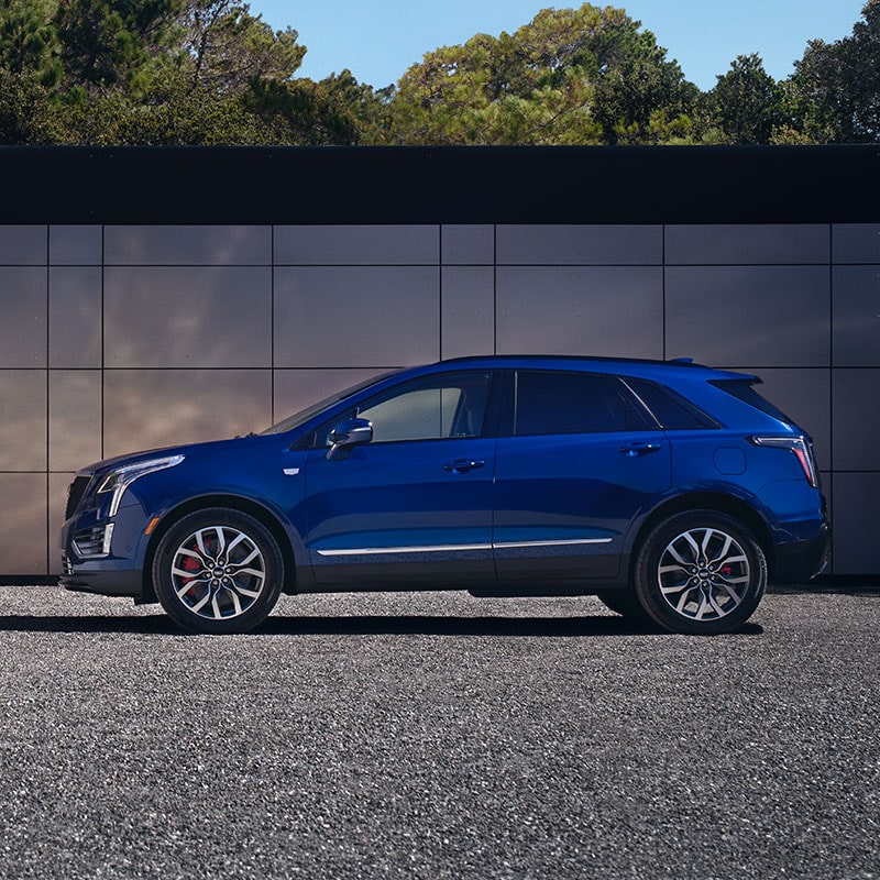 The Dark Moon Blue Metallic Cadillac XT5 Parked in Front of a Building Wall