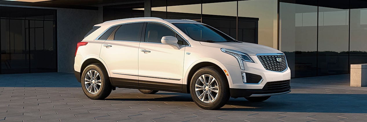 The Crystal White Tricoat Cadillac XT5 Parked in Front of a Modern Home