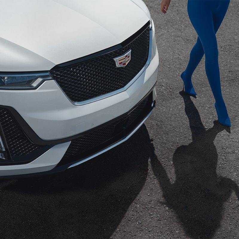A Person Walks Along Side of a Parked Cadillac XT6