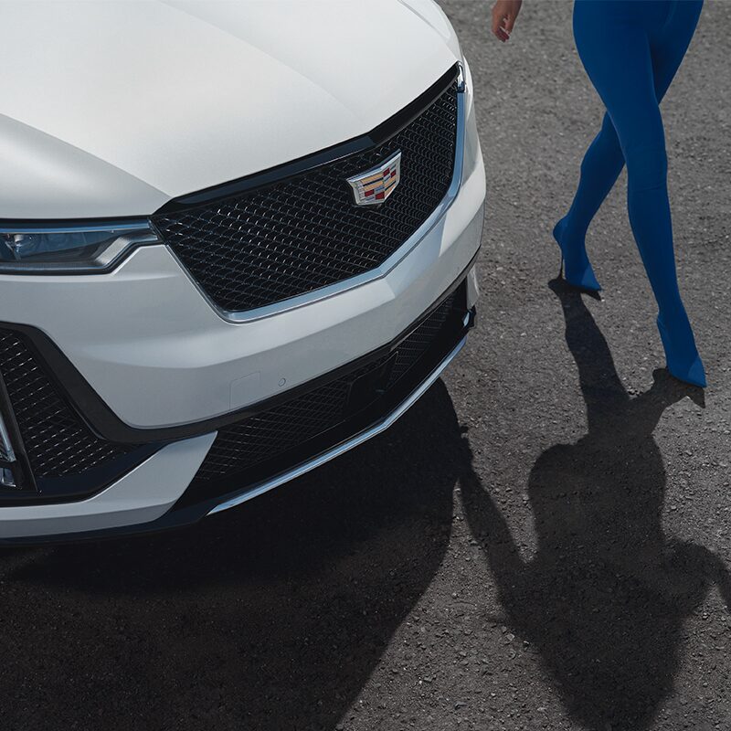 A Person Walks Along Side of a Parked Cadillac XT6
