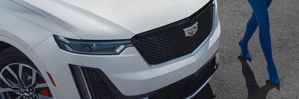 A Person Walks Along Side of a Parked Cadillac XT6