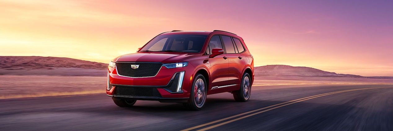 The Cadillac XT6 Driving on an Open Road in the Desert During Sunset
