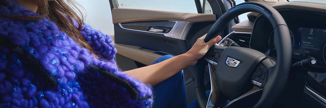 A Woman Uses Both Hands to Hold the Steering Wheel of the Cadillac XT6