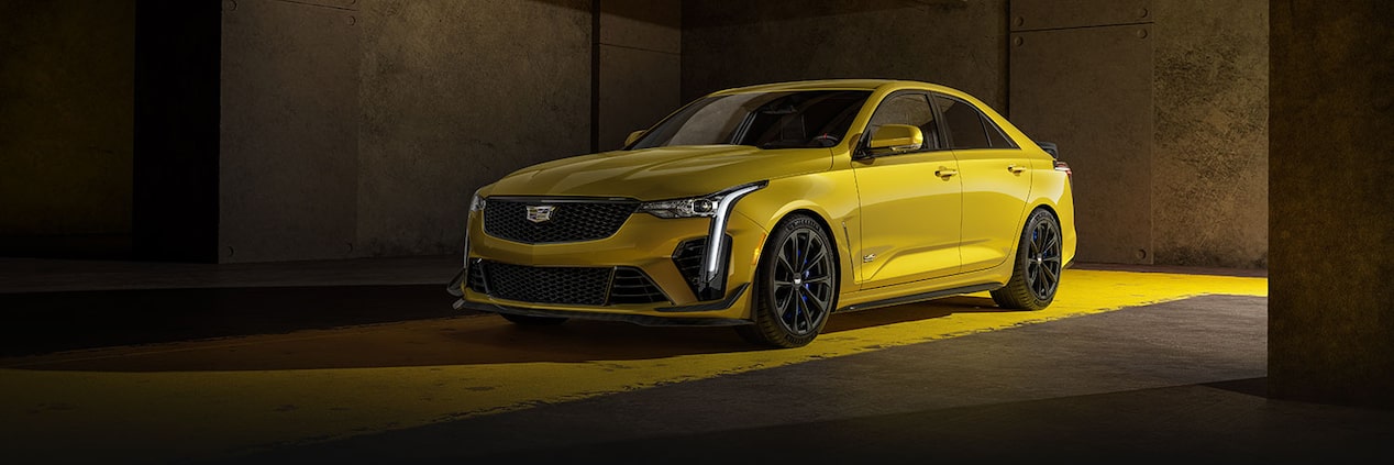 The Cadillac CT4-V Sitting in a Parking Garage with Yellow Light Illuminating from the Vehicle