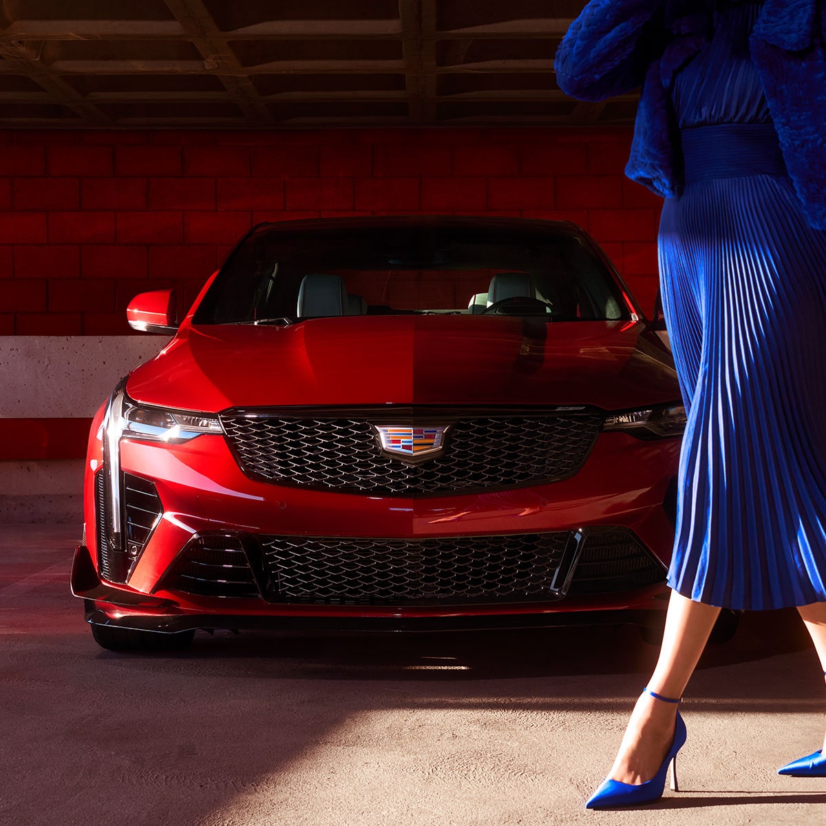 A Woman in a Blue Dress Walking Infront of a Cadillac CT4-V While Parked in a Garage