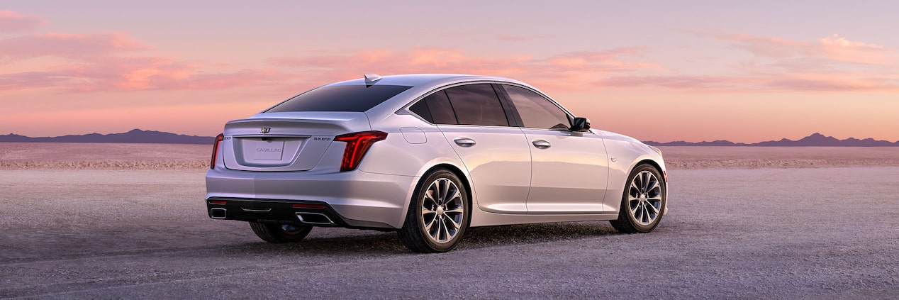 Cadillac CT5 2023 en Blanco Nevado circulando a toda máquina, con un atardecer dorado de fondo