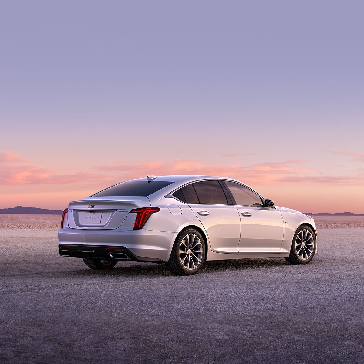 Vista trasera del Cadillac CT5 en color Blanco Cristal tricapa estacionado de cara al atardecer