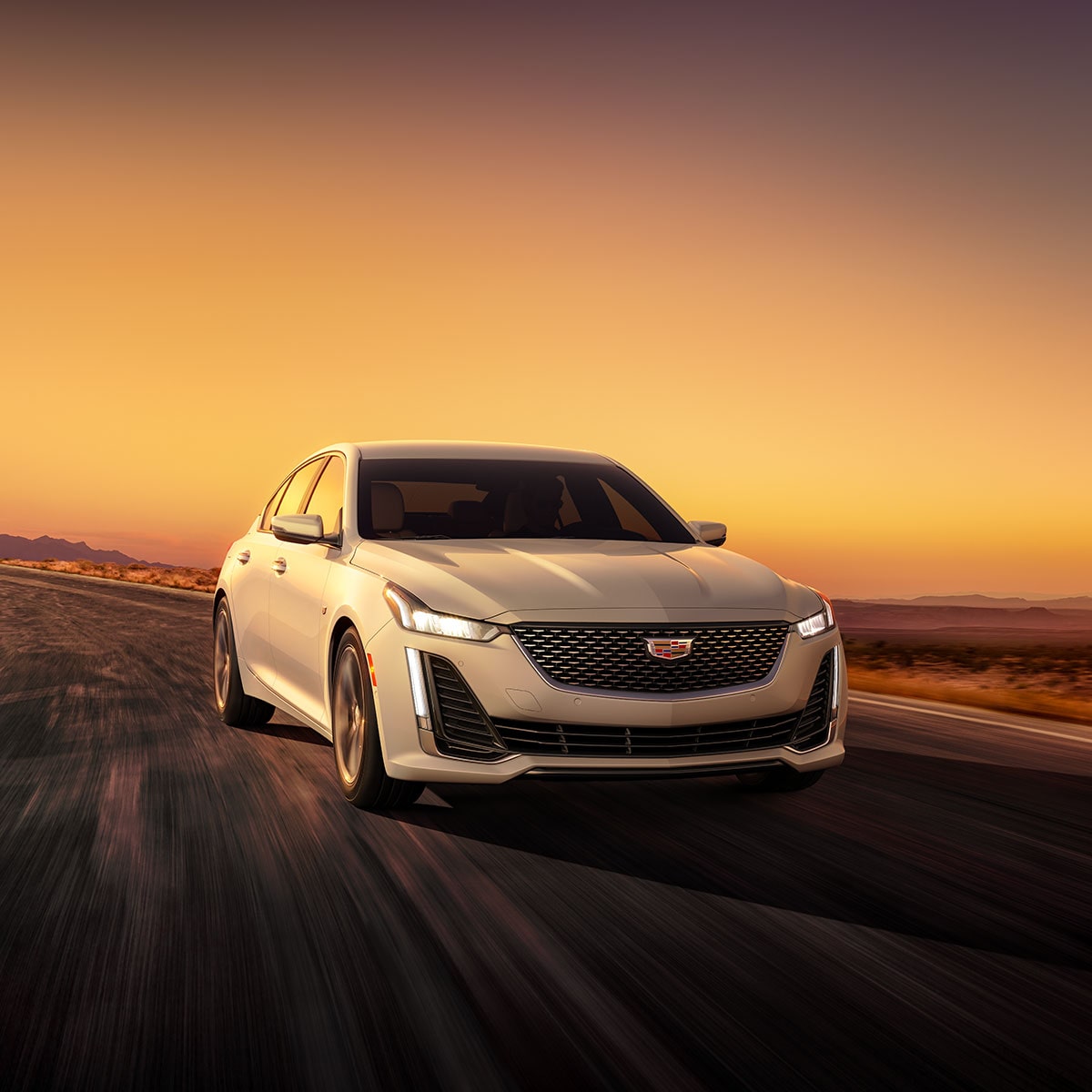 Cadillac CT5 2023 circulando, con un atardecer de fondo