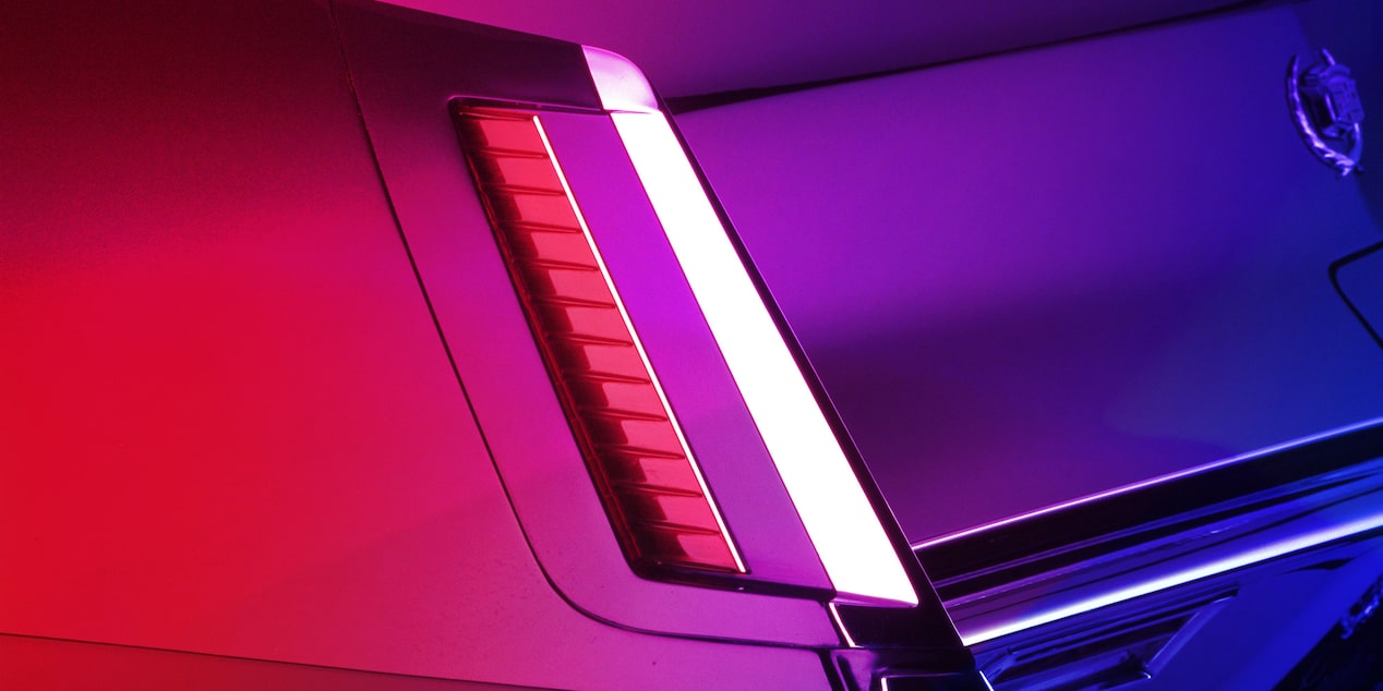Faro trasero de un Cadillac clásico en una sala de exposición iluminada en rojo