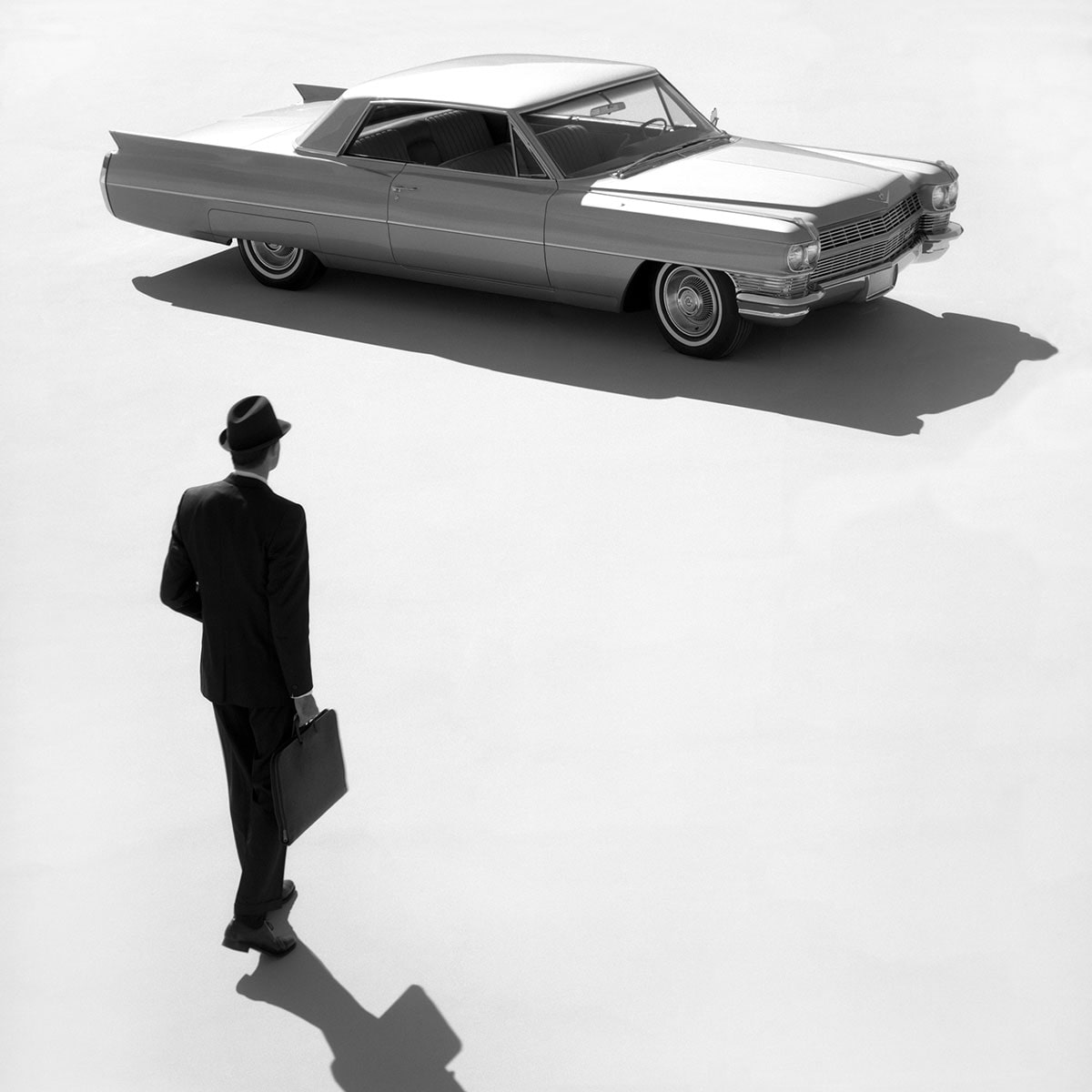 Un hombre de negocios se acerca a su Cadillac de Ville 1950
