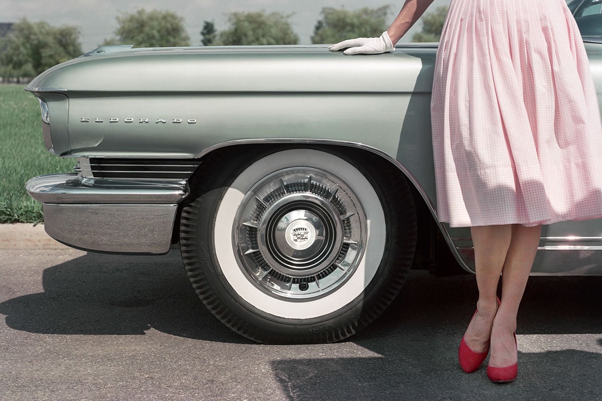 Una mujer posa junto al emblema de Cadillac Eldorado