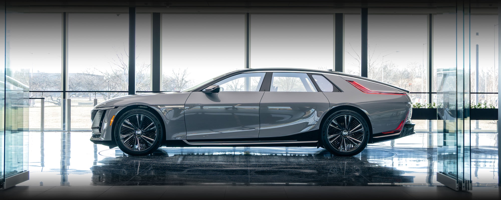 A Red Cadillac CELESTIQ Car is Parked Indoors, Showcasing its Sleek Side Profile.