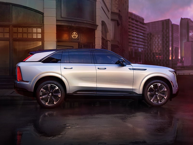 Perfil lateral de una Cadillac Escalade IQ 2025 estacionada en el centro de una ciudad