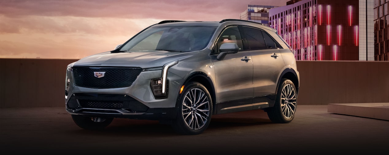 Vista frontal lateral de la Cadillac XT4 2025 estacionada en un piso superior de un garaje de una ciudad