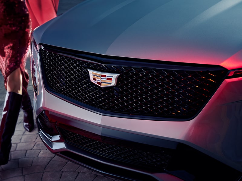 Primer plano de una mujer pasando por delante la parrilla de la Cadillac XT4 2025
