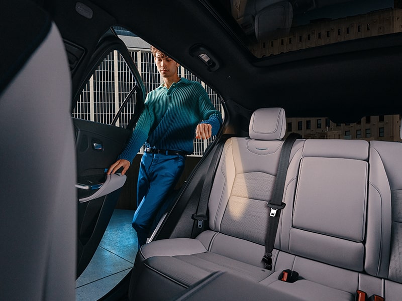 Un hombre abriendo la puerta para ingresar a uno de los espaciosos asientos traseros de una Cadillac XT4 2025