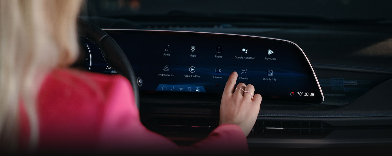 Una mujer utilizando la pantalla táctil del sistema de infoentretenimiento de la Cadillac XT5 2025