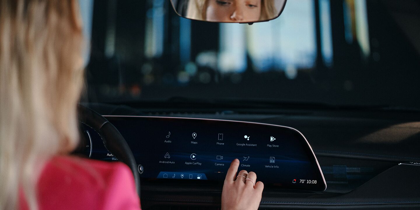 Woman using the Cadillac XT-4 33 inch LED touchscreen dashboard