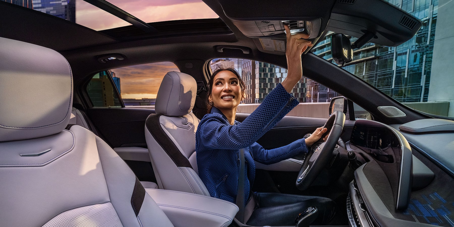 Women pressing the overhead button next to the interior lights to open the XT-4 panoramic moonroof