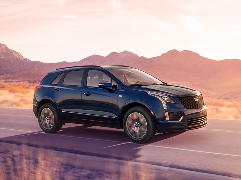 The 2025 Cadillac XT5 Driving Through a Western Landscape During Golden Hour