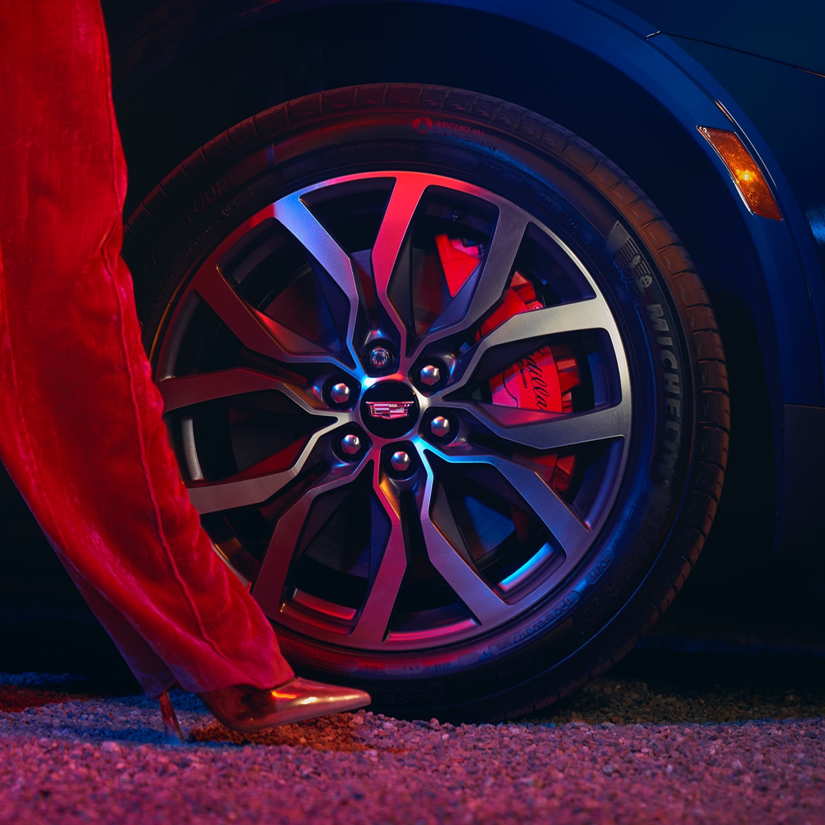 Una mujer pasando por delante de un neumático de la Cadillac XT5