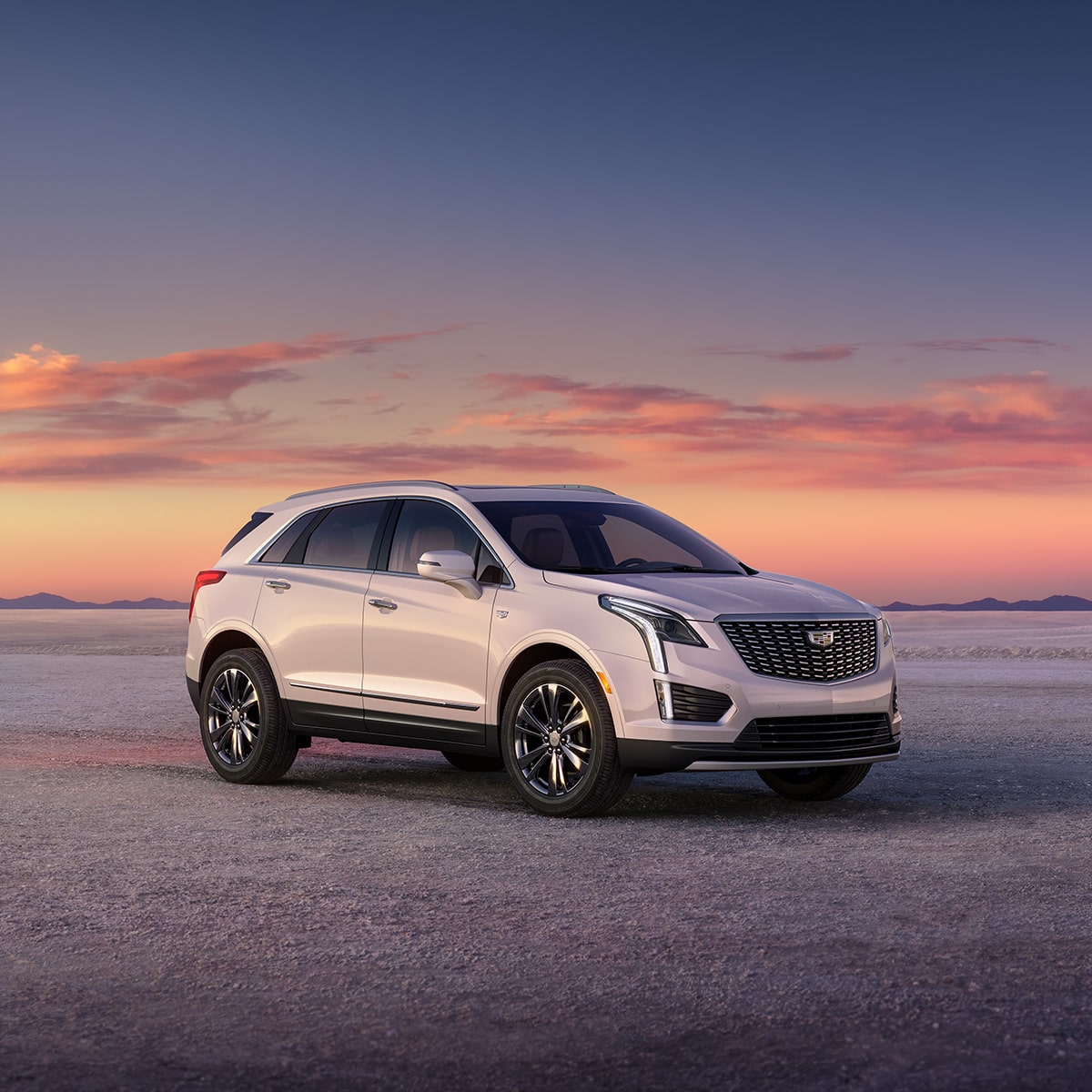 Cadillac XT5 en Blanco Cristal Tricapa estacionada en el desierto, durante un encantador atardecer