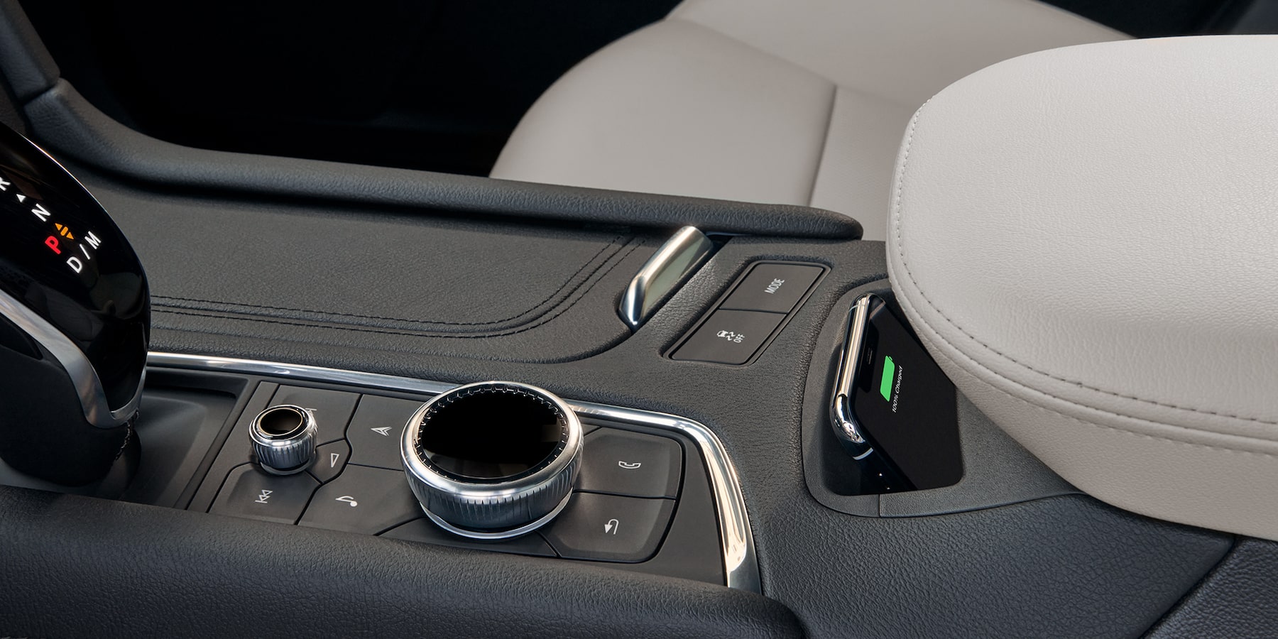 Center console view of the XT5 wireless charging pocket for I phone and Android, hands free calling dial and gear shifter