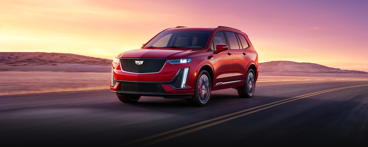 The Cadillac XT6 Driving on an Open Road in the Desert During Sunset