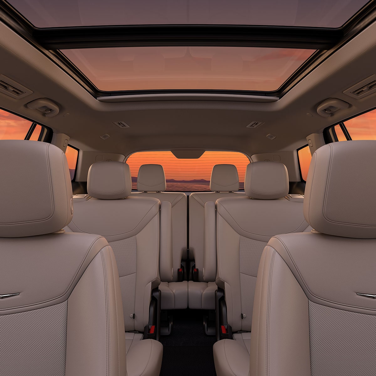 Tres filas de asientos de piel en Tostado en el interior de la nueva Cadillac XT6 estacionada, al atardecer