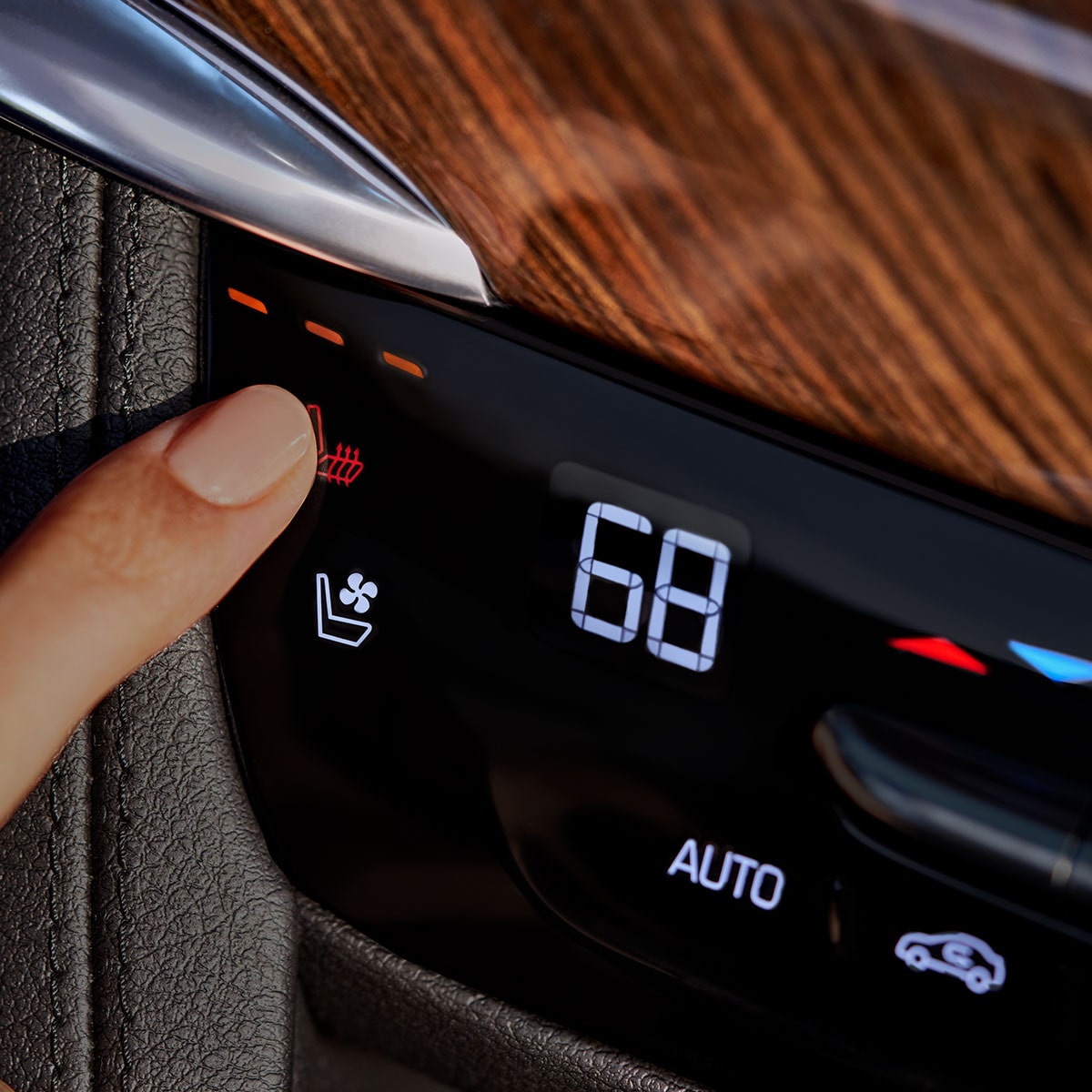 Una persona seleccionando la función de asientos traseros calefaccionados en el interior de la nueva Cadillac XT6
