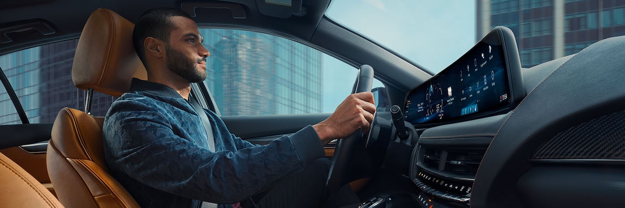 Passenger View of Man Driving a 2025 Cadillac CT5 Through the City