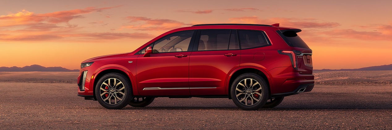 El destacado perfil lateral de una Cadillac XT6 estacionada en un desierto despejado durante el atardecer