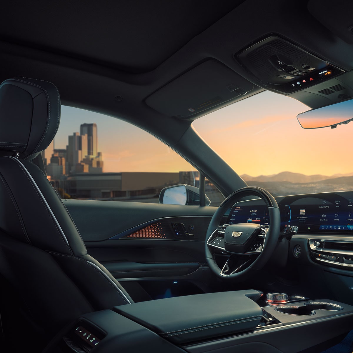 Passenger View of the Driver's Side of the 2025 Cadillac LYRIQ Overlooking a City During a Sunset
