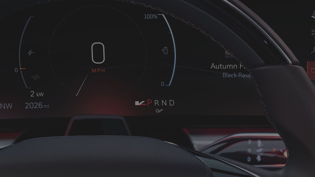A Digital Cadillac LYRIQ Driver Display Showing Torque Output, Speed, And PRND Gear Indicators Partially Framed By the Steering Wheel.