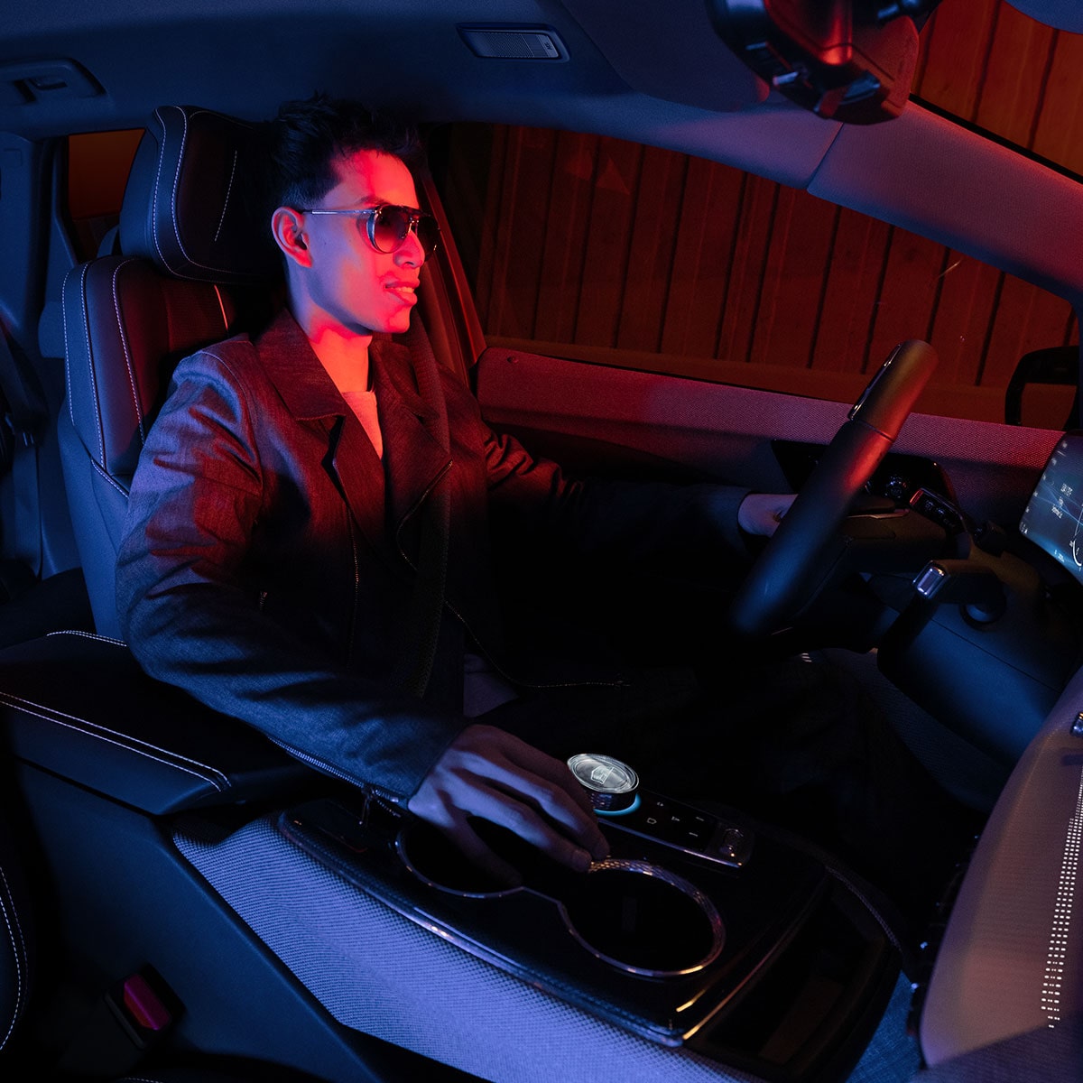 Vista del acompañante de un hombre que conduce Cadillac OPTIQ 2025 en un semáforo en rojo