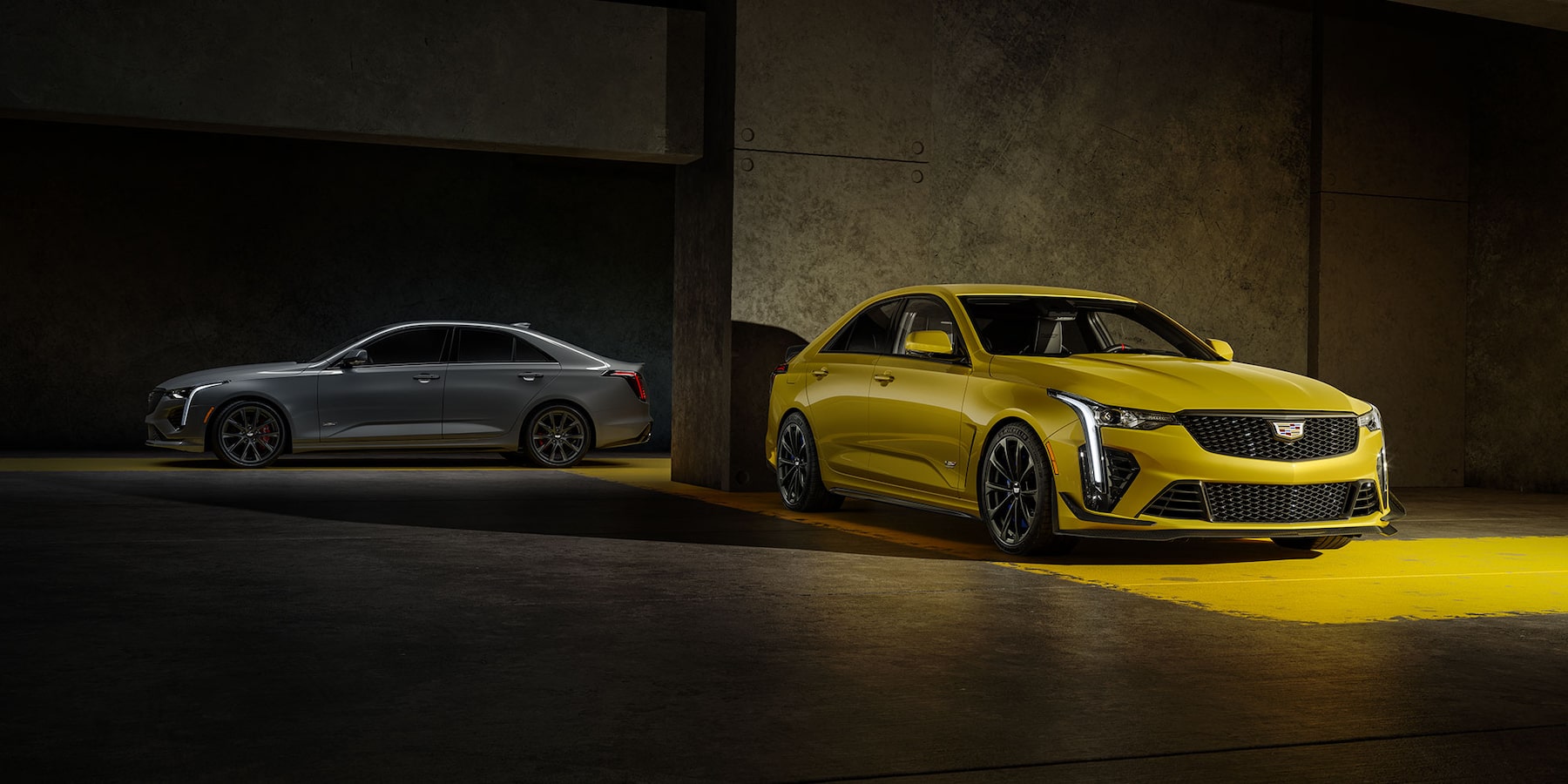 Silver and gold CT-V 4 Cadillac Blackwing's in parking garage.