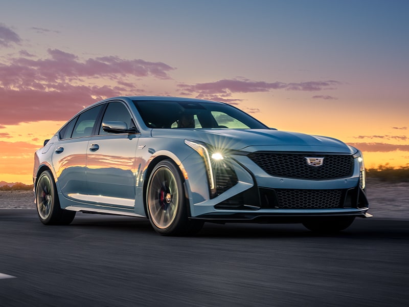 Three-Quarters View of a 2025 Light Blue Cadillac CT5-V Parked on the Road under an Evening Sky