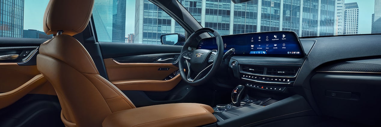 Driver's Side of 2025 Cadillac CT5 Tan and Jet Black Accent Interior Outlooking Industrial Building