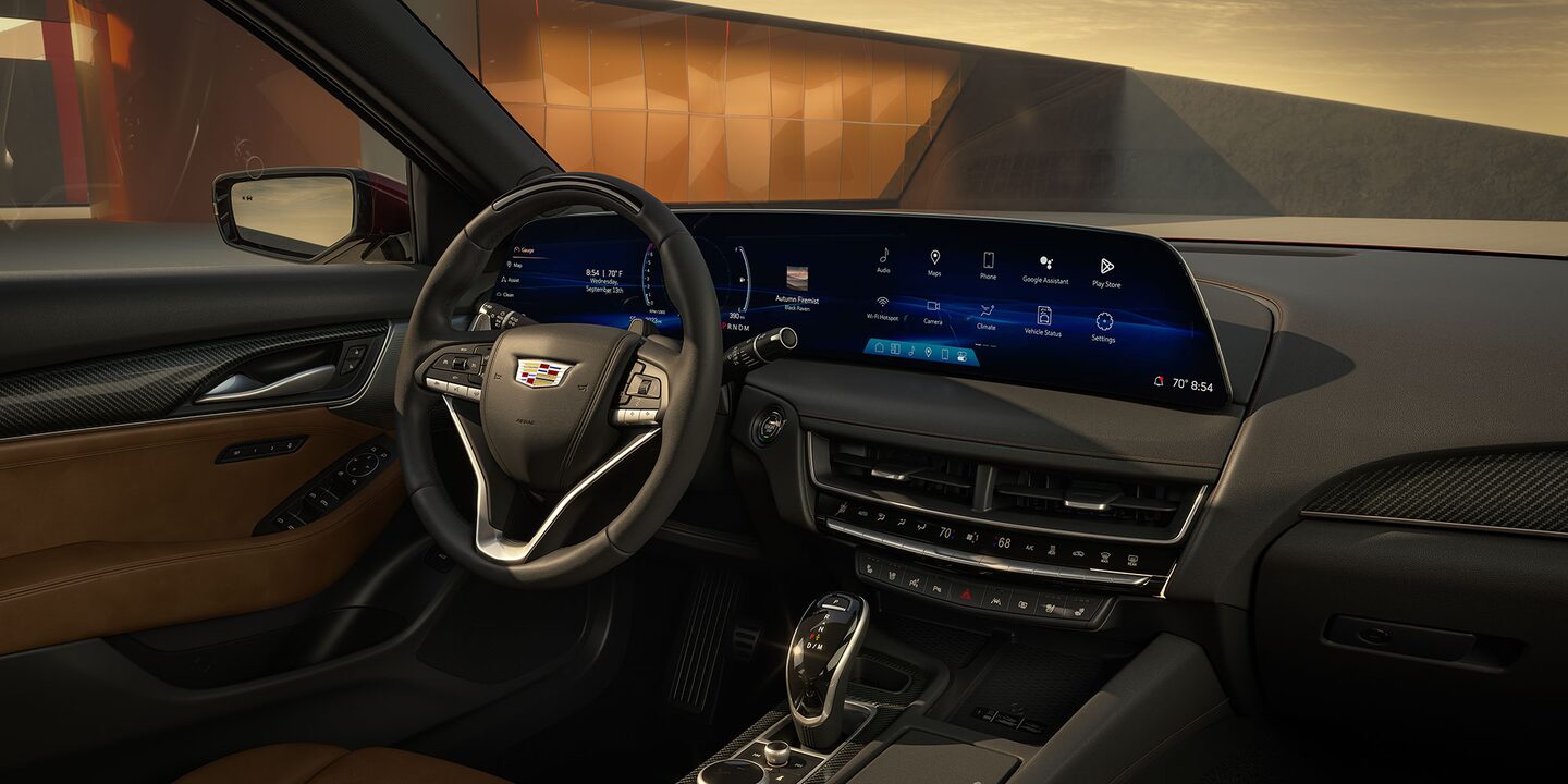 passenger view of the driver side Brown leather stitched seat and door with gloss carbon fiber trim accents