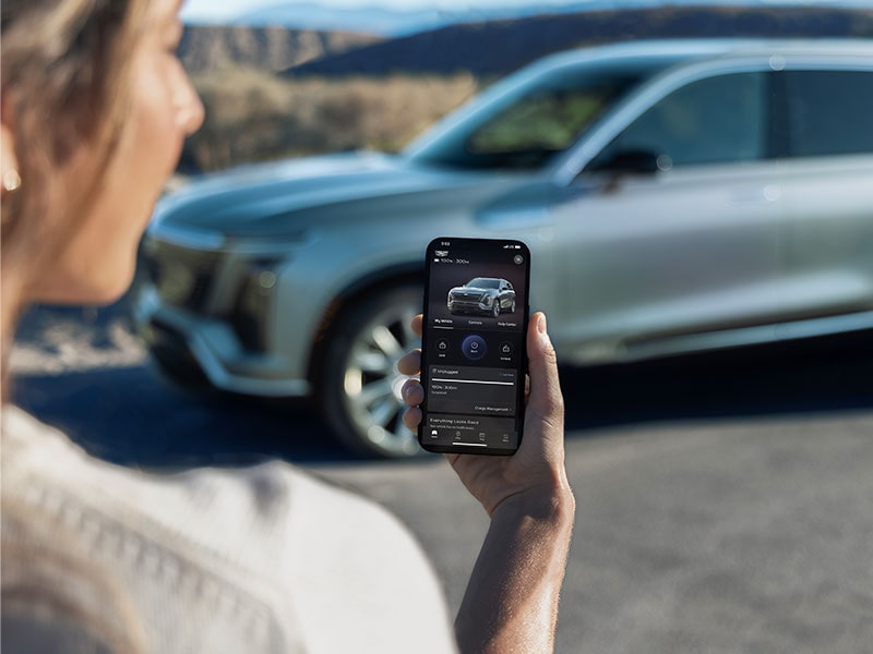 Close-up of a Woman Checking a 2026 VISTIQ Charging Range on the myCadillac Phone App