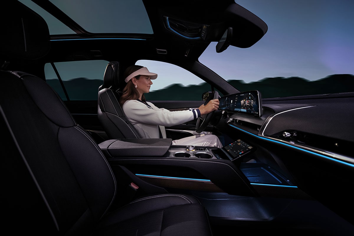 Passenger Side View of a Woman Driving the 2026 Cadillac VISTIQ Luxury Electric SUV