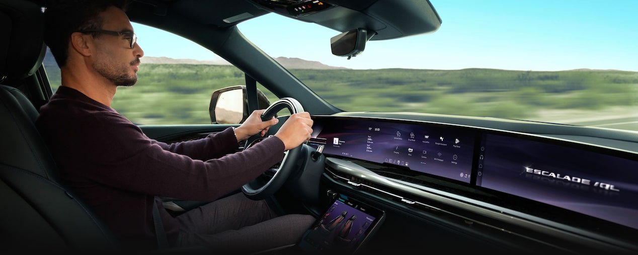 Passenger View of a Man Driving the 2026 ESCALADE IQL Large Electric SUV in the Desert