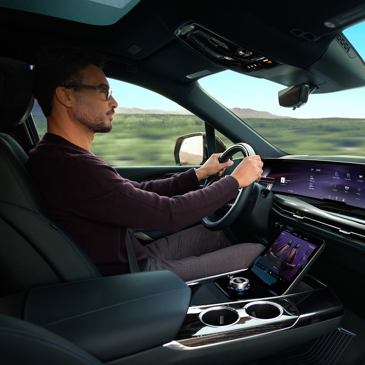 Passenger View of a Man Driving the 2026 ESCALADE IQL Large Electric SUV in the Desert