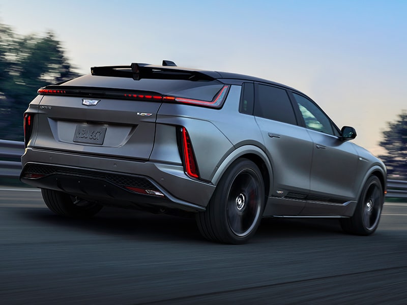 Three-quarter Rear View of a Silver 2026 Cadillac LYRIQ-V Speeding Down a Road